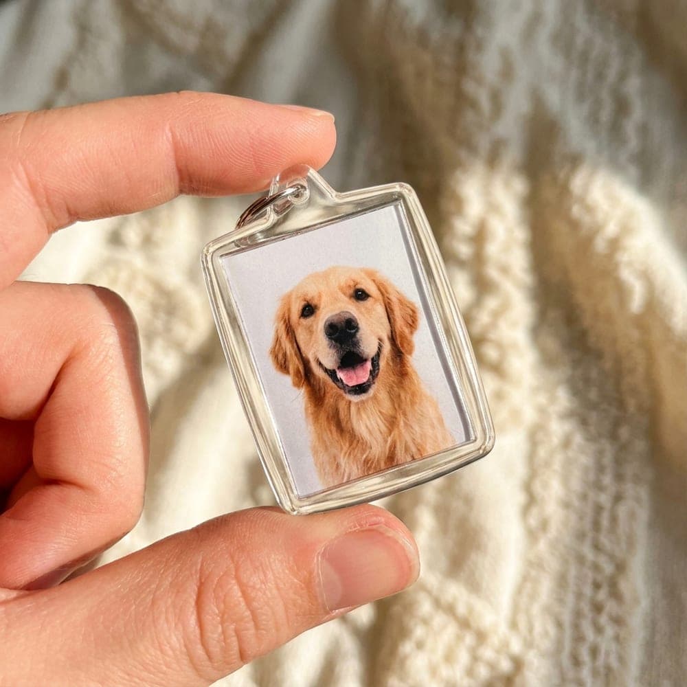 Porte-clés acrylique photo d'un chien, tenu entre les doigts